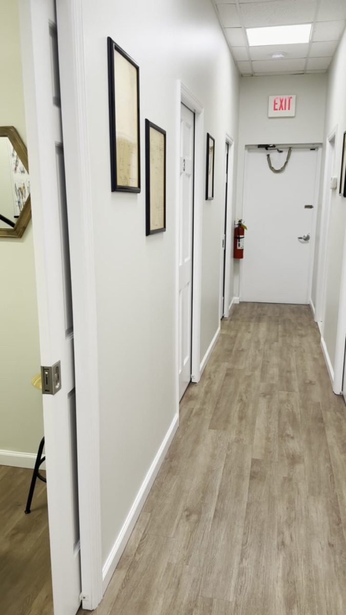 Beyond Wellness clinic hallway lined with framed credentials